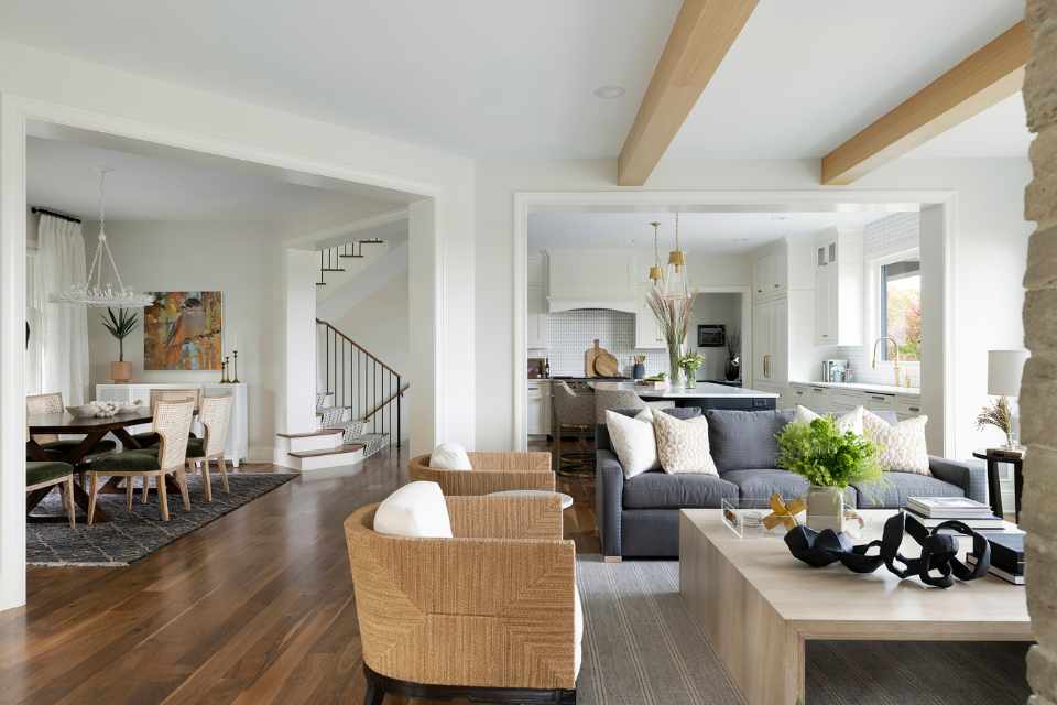 open concept living room dining kitchen with exposed wood beams and greenery